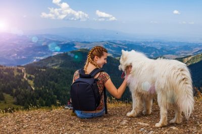 Woman with dog and mountain with sky